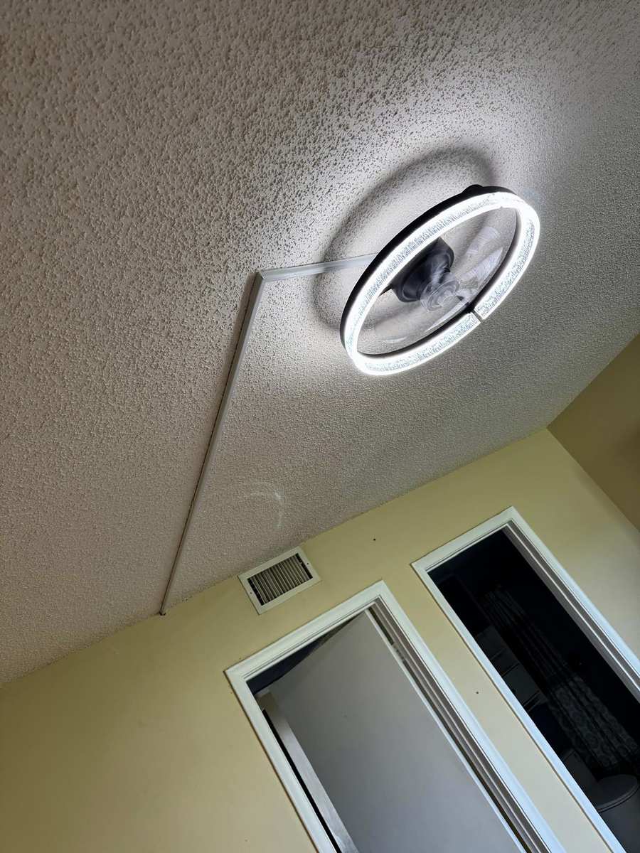 Round LED ceiling fixture installed on a textured ceiling