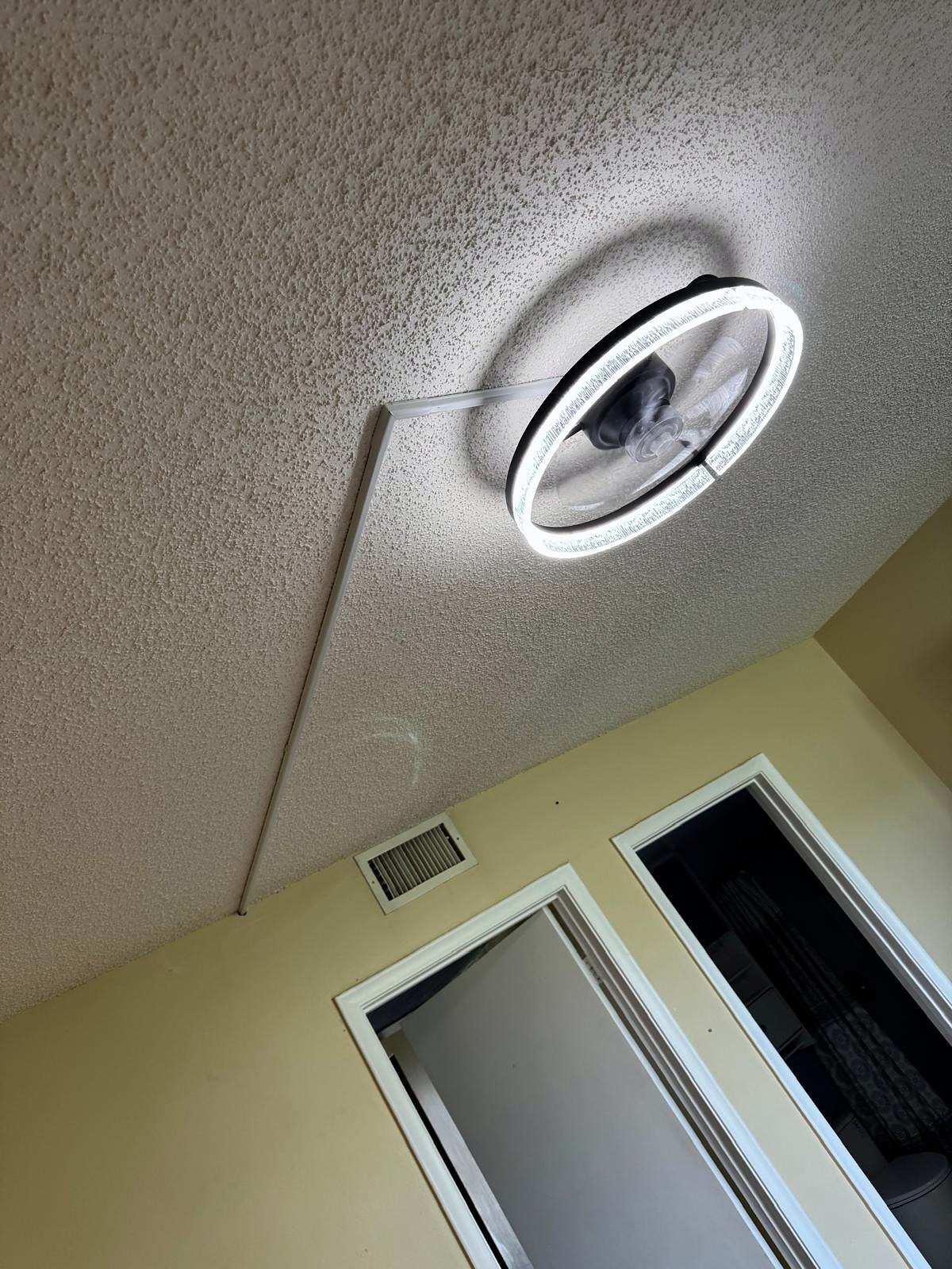 Round LED ceiling fixture installed on a textured ceiling