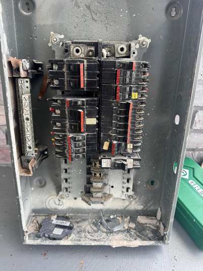 Inside an old breaker panel: rust, debris and worn breakers