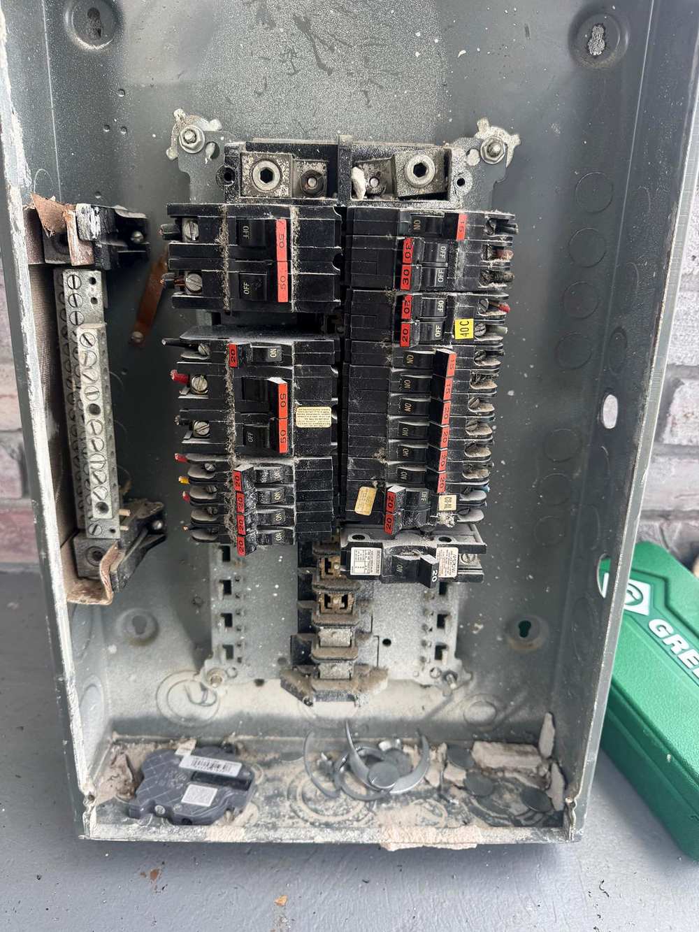 Inside an old breaker panel: rust, debris and worn breakers