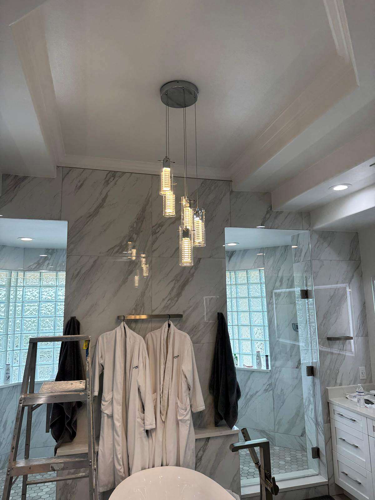 Cluster of glass pendant lights hanging in a marble bathroom