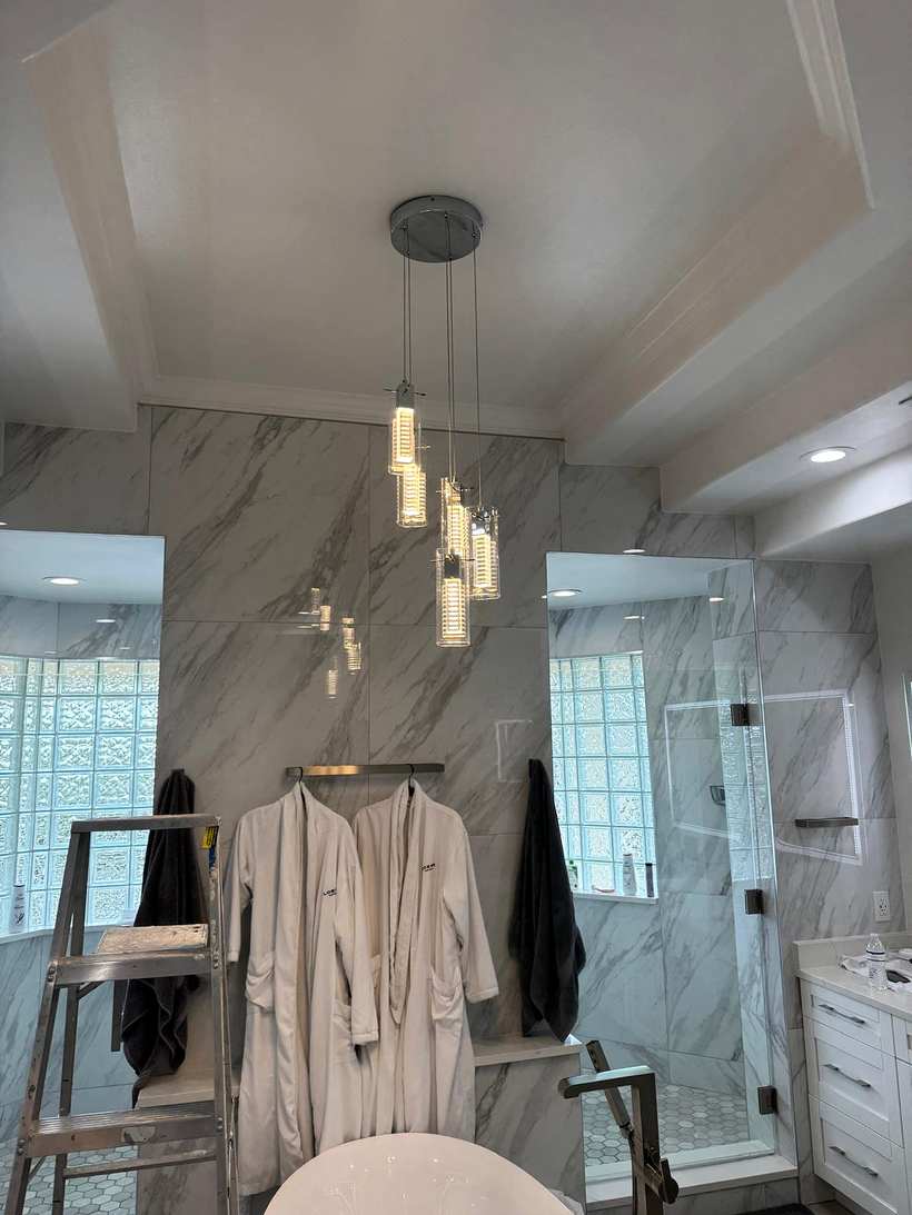 Cluster of glass pendant lights hanging in a marble bathroom